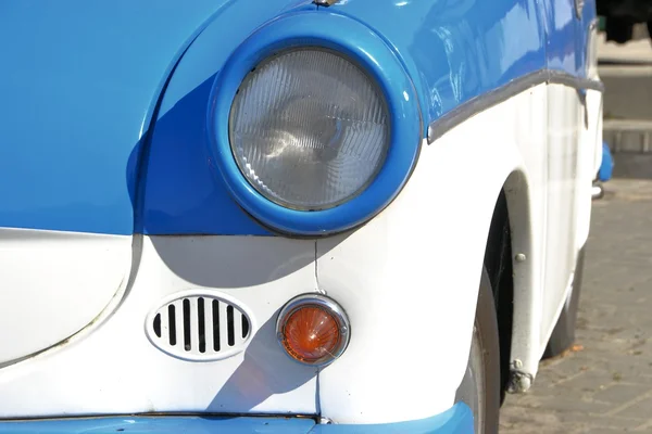 A blue-white classic car on the roadside