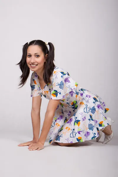 A girl with pigtails in colorful retro dress