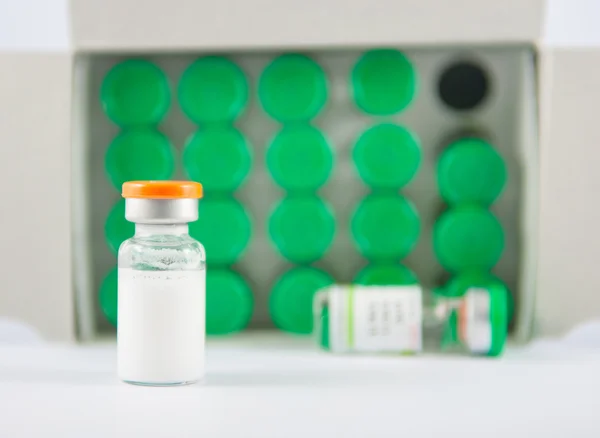 Injection vial on green vials background