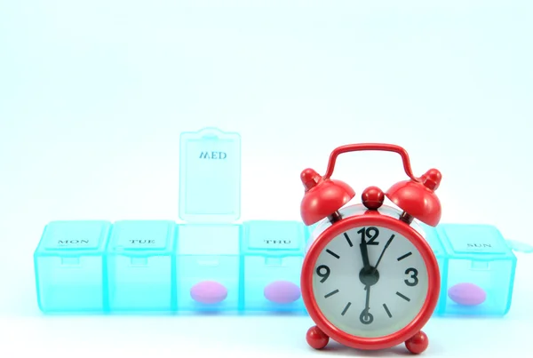 Weekly pill box and red clock