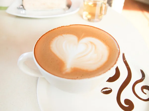 Cup of coffee with heart pattern in a white cup