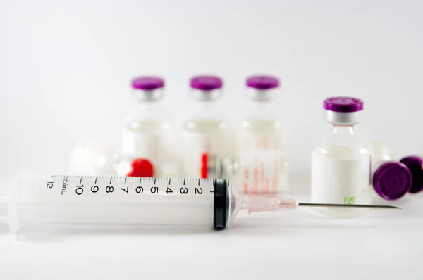 Purple cap injection vials and syringe show medicine concept
