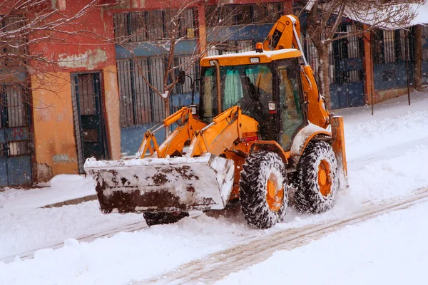 Cleaning street from snow by bulldozer on a street