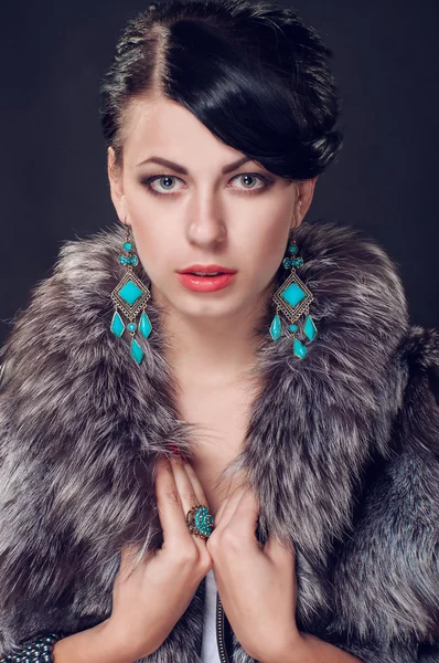 Young woman in a fur coat in  earrings