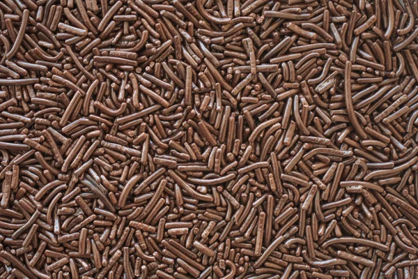 A bed of brown chocolate sprinkles used for cake decoration and dessert toppings