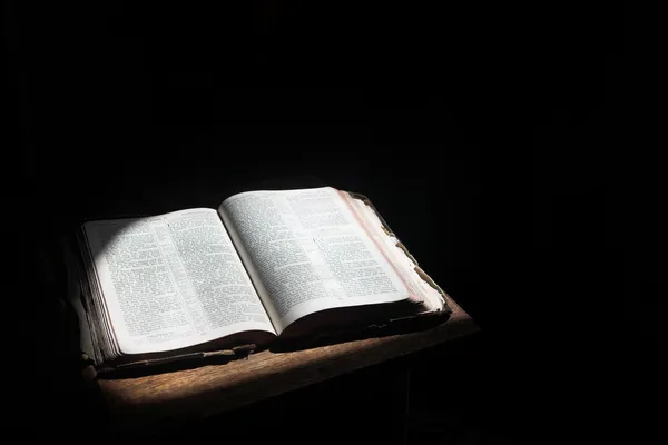 Old open bible lying on a wooden table — Stock Photo #22098073