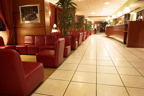 The interior of a hotel with tiled floors and leather couches