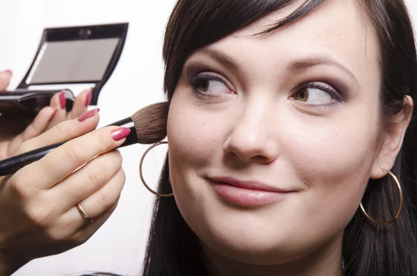 Makeup artist deals powder on the face model