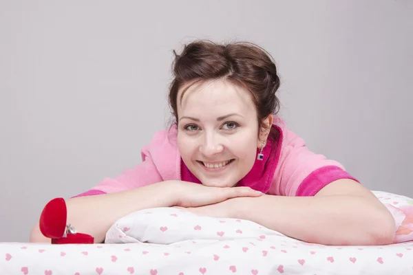 Girl is happy with present, lying in bed