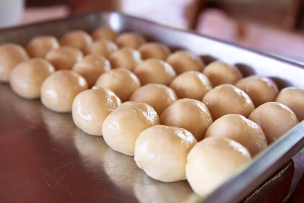 Raw cheese buns on the oven-tray