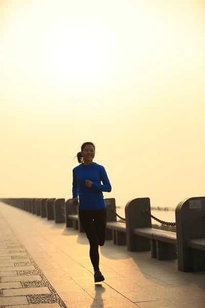 Woman jogging at sunrise seaside