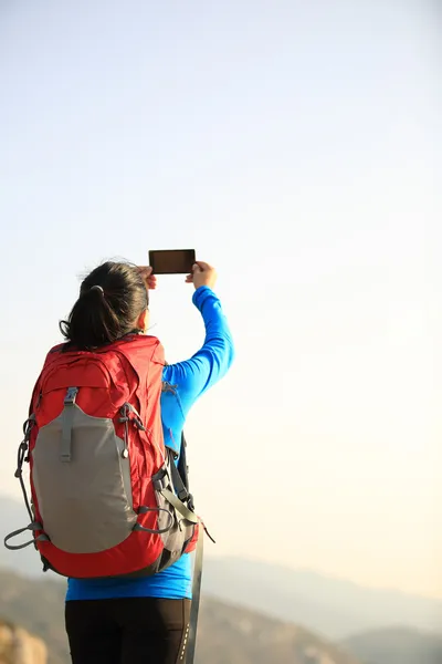 Hiking woman taking photo with phone
