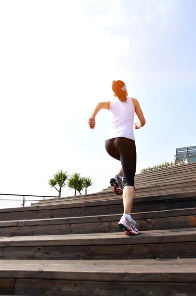 Runner athlete running on seaside stone stairs