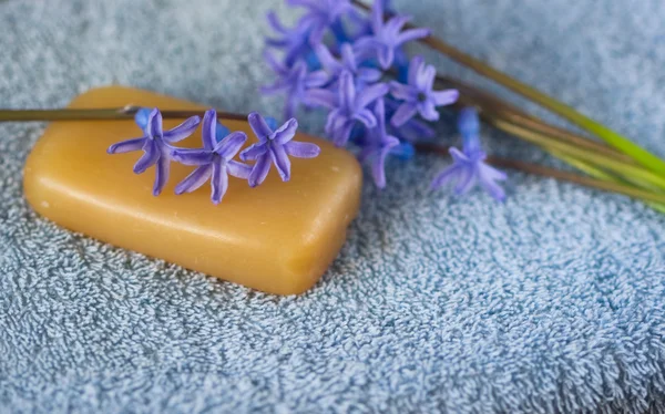 Flower on a piece of natural soap and bouquet of flowers