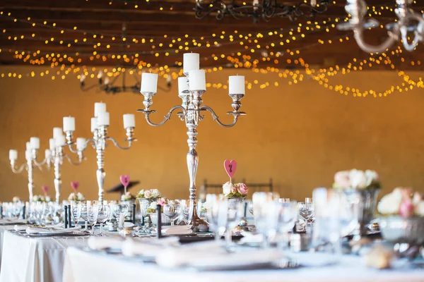 Wedding reception hall with decor including candles and cutlery