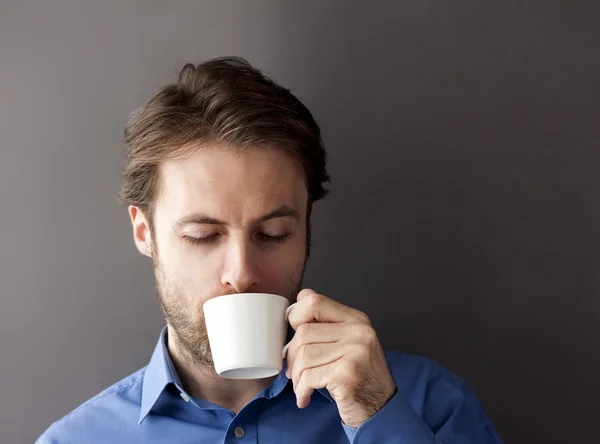 Forty years old sleepy office worker man drinking morning coffee