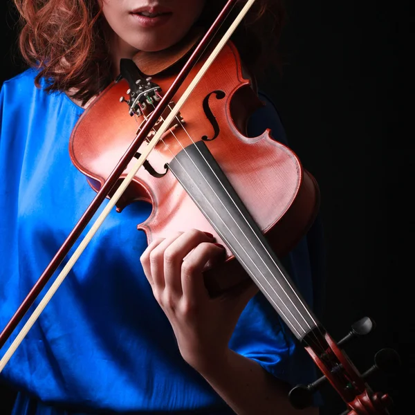 Playing the violin. Musical instrument with performer hands on dark background.