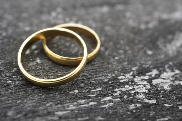 Gold wedding rings on old wood