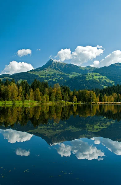 Wharf by the Schwarzsee in Austria with mirror reflection of the landscape