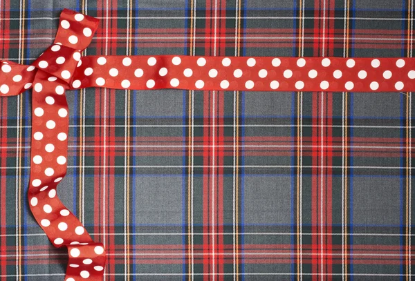 Tartan background texture with polka dots and red ribbon