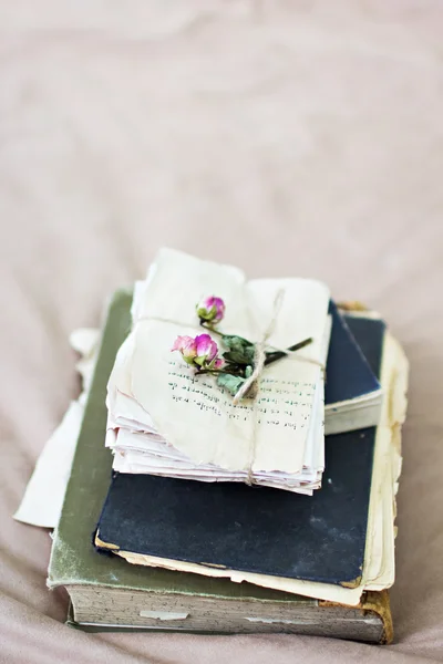 Old books and letters with dried rose.