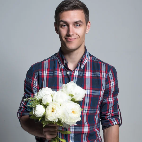 Young beautiful headsome attractive enamored man casual stule with flowers