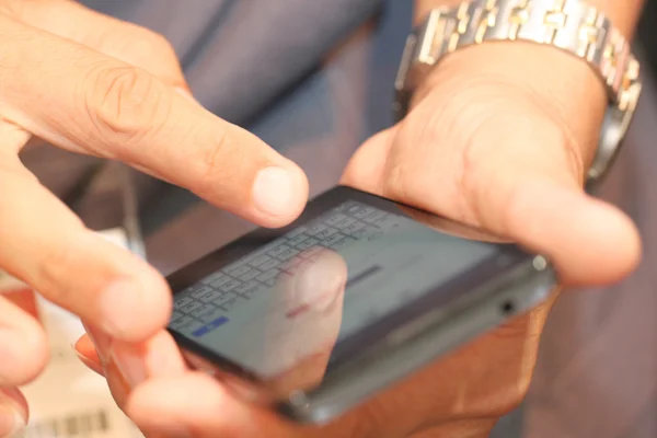 Fingers of men use touchscreen the smartphone.