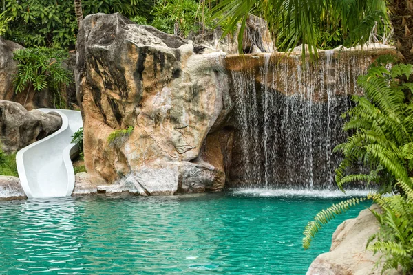 Swimming pool with waterfall and slide at high resolution