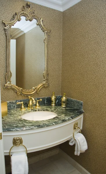 Brass taps on marble sink and baguette framed mirror