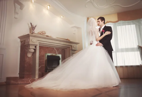 Bride and groom kiss in luxury interior