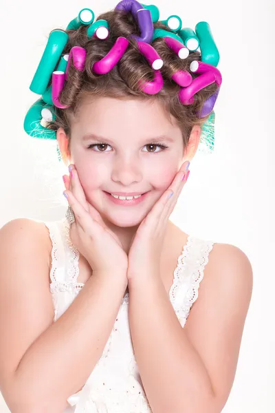 Lovely little girl portrait in curlers and pajamas, skincare kid beauty and glamour.