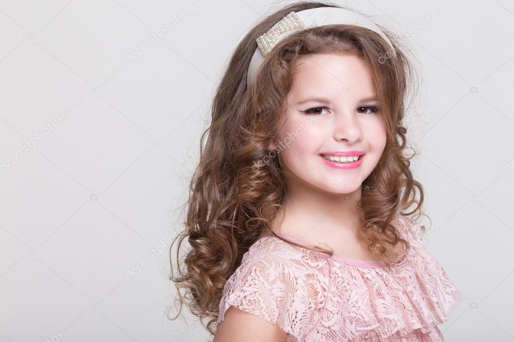 Fashion little girl isolated, lovely girl in beige dress in studio