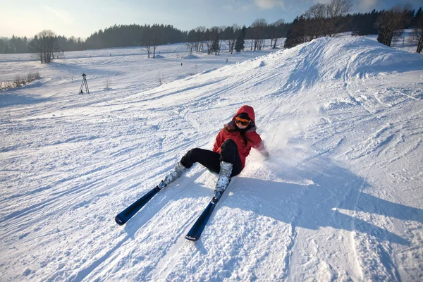 Woman skiing down the hill and falls