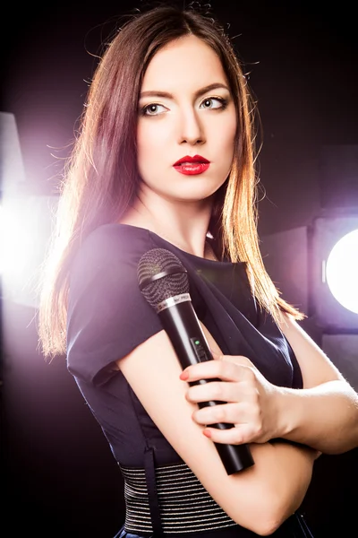Close-up portrait of beautiful elegant woman with microphone
