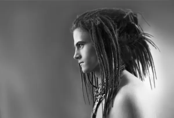 Black and white profile portrait of a young man with dreadlocks