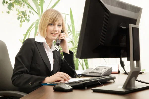 Female executive talking on phone in office
