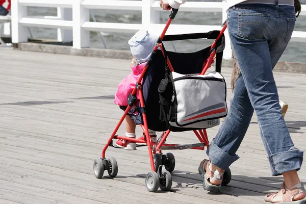 Mother with her child in stroller walking