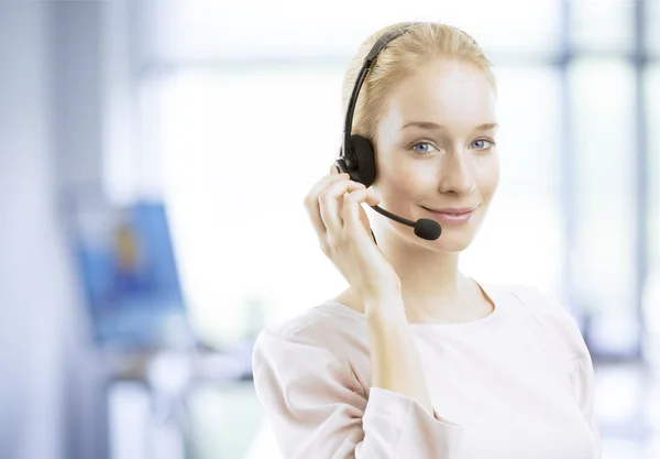 Smiling young female customer service agent with headset