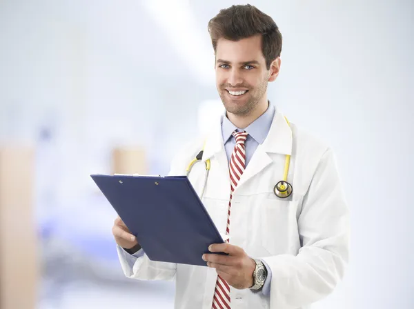 Portrait of happy male doctor with clipboard