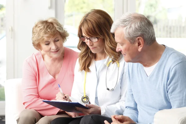 Elderly couple consulting with doctor