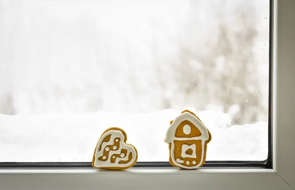 Loneliness. Christmas gingerbread cookies on the winter window with snow with copy space for your text