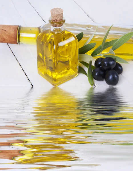Oil and olives with water reflection