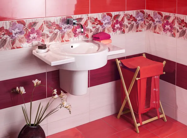 Detail of a modern bathroom with floral motif tiles and accessor