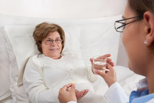 Doctor giving medication to senior patient