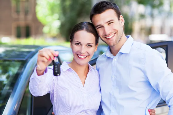 Young couple with keys to new car