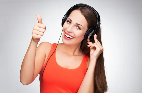 Woman with headphones showing thumbs up