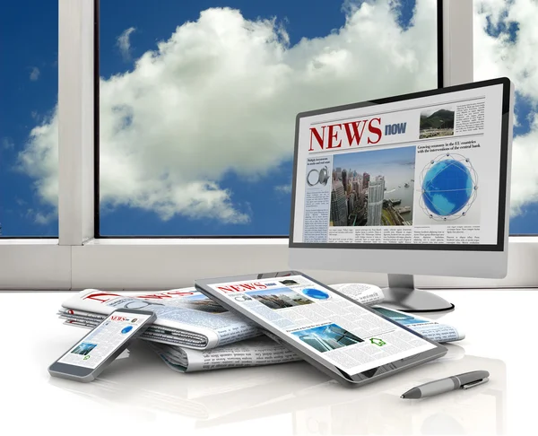 Pc, tablet, cell phone and daily newspaper on white desk