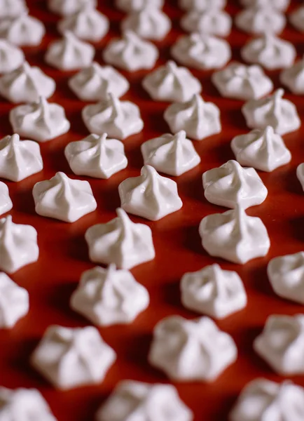 White meringue on a red baking mat