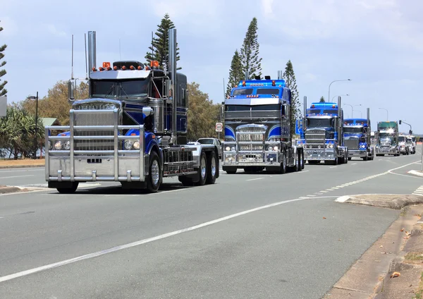 Convoy of blue trucks on highway