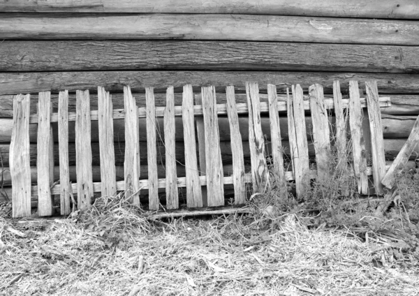 Dilapidated and falling apart picket fencing in black and white